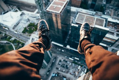 feet dangling over skyscrapers